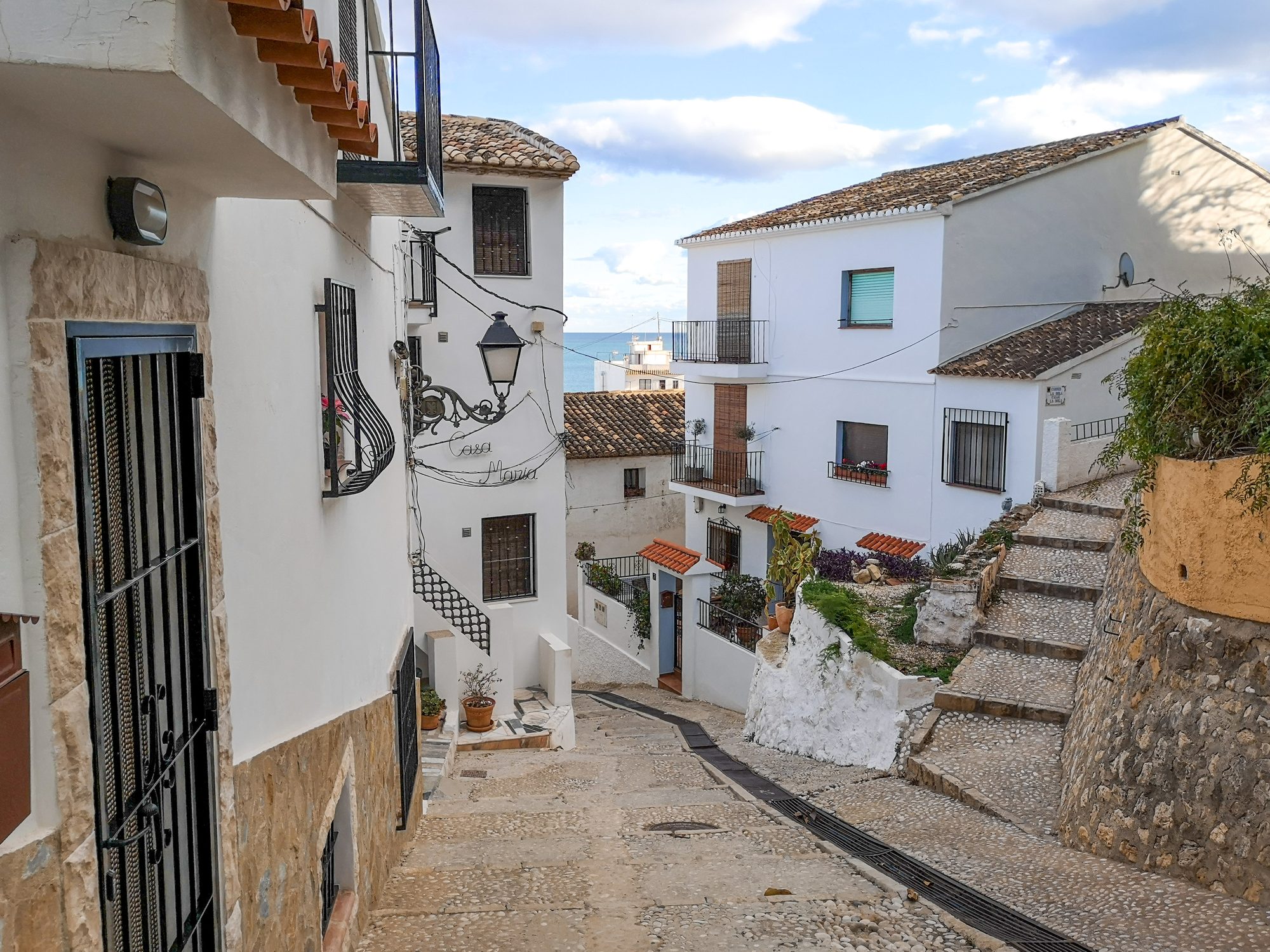 Cobbled steps between white houses with a glimpse of the sea, Altea Old Town (Casco Antiguo)