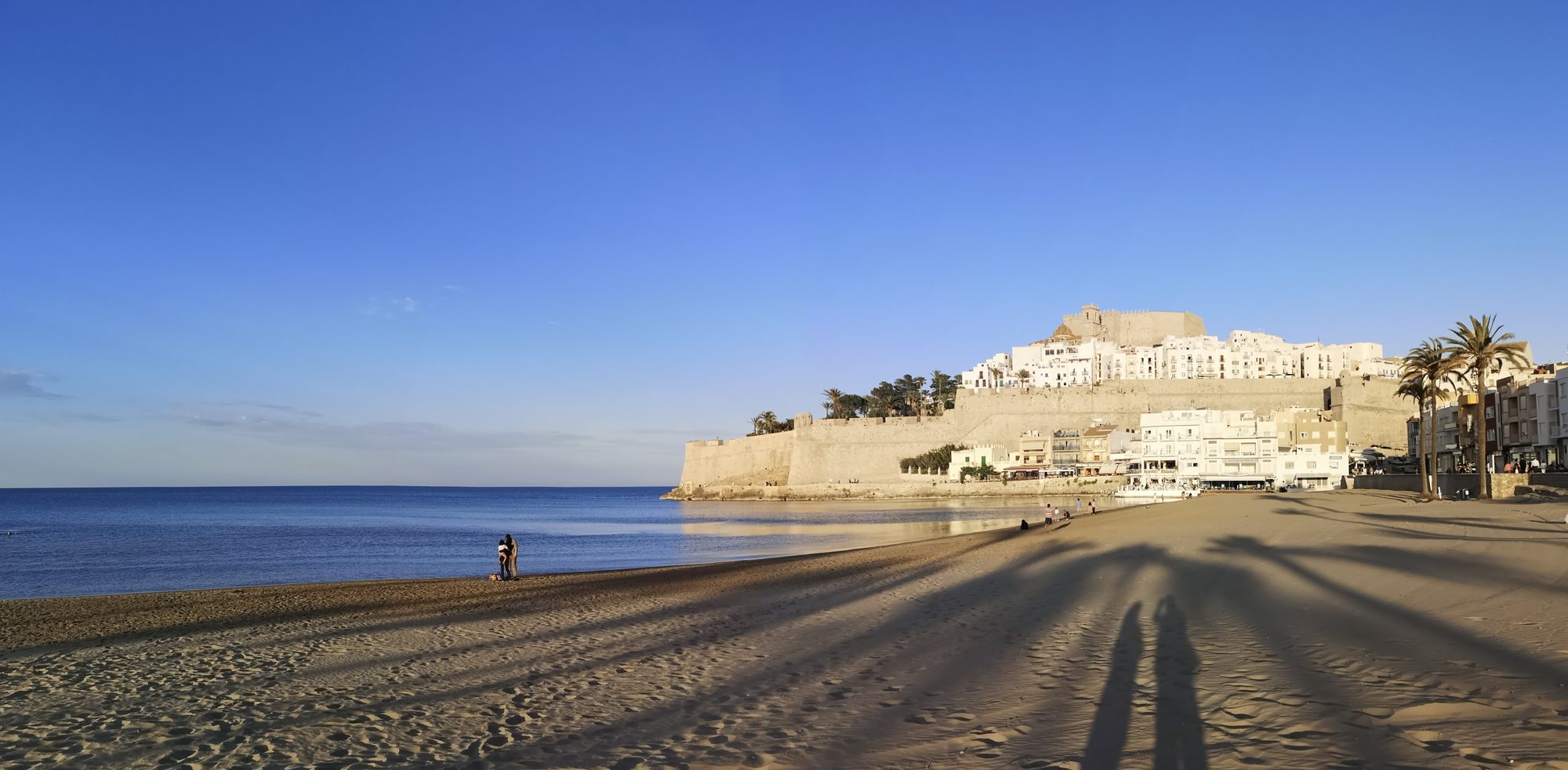Peñíscola beach at dusk with Peñíscola Castle (Castillo de Peñíscola) on its promontory