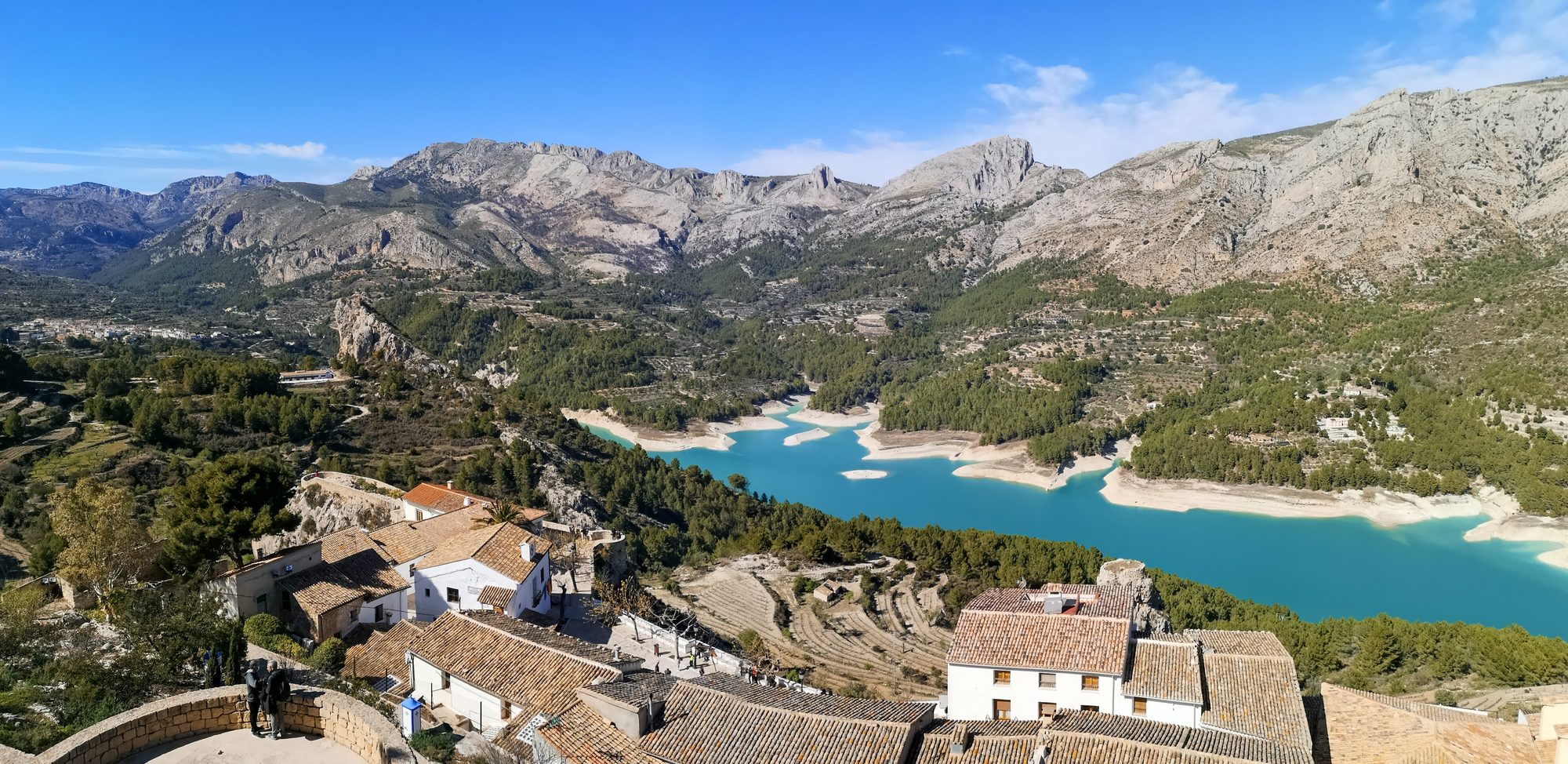 Guadalest Reservoir (Embalse de Guadalest) below the mountains and the village of Guadalest